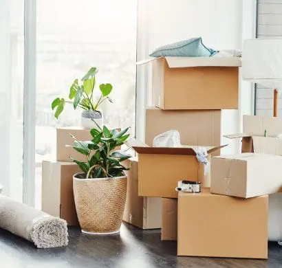 Home in the process of being packed up with boxes stacked and rug rolled up for moving